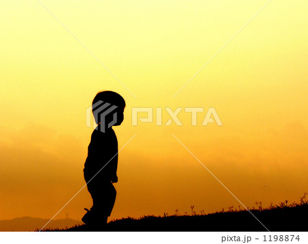 子供 夕焼け 影絵 男の子の写真素材