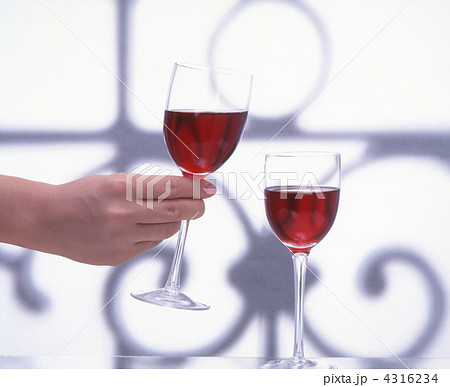 ワイン ワイングラス グラス持つ手 背景ボカシの写真素材
