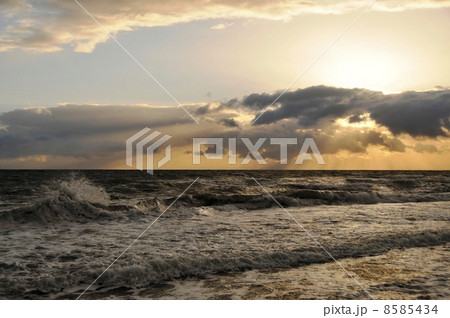 波しぶき 夕暮れ オレンジ色の海 荒れる海の写真素材