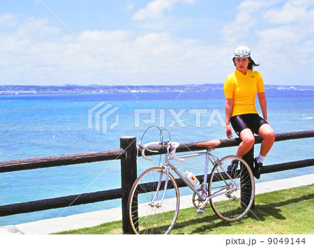 サイクリングウェア 女性 沖縄 海岸の写真素材