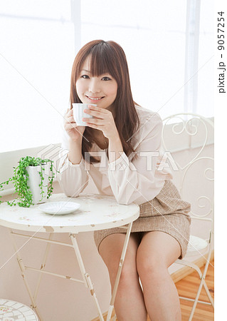 女性 ミニスカート 笑顔 座る 女の子 日本人 明るい 屋内の写真素材