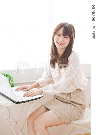女性 ミニスカート 笑顔 座る 女の子 屋内 大学生 専門学生 学生の写真素材