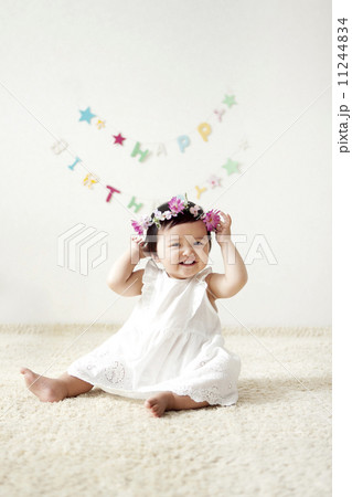 赤ちゃん 笑顔 花冠 女の子の写真素材