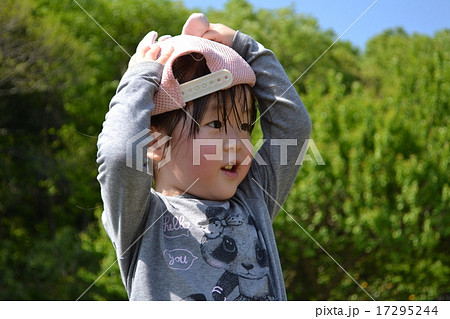 帽子を押さえる 帽子の写真素材