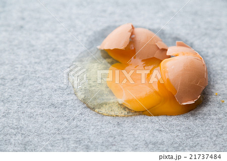 床に落として割れた卵の写真素材