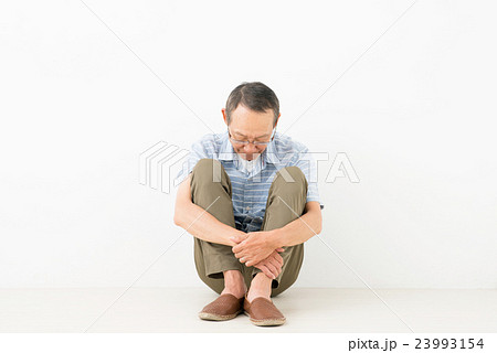 男性 シニア 体育座り 落ち込むの写真素材