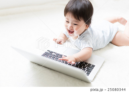 赤ちゃん ノートパソコン 興味 触るの写真素材