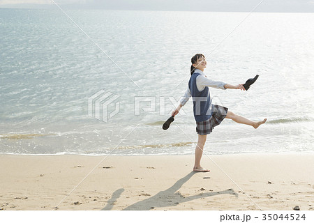 海 夕焼け 女の子 波打ち際の写真素材