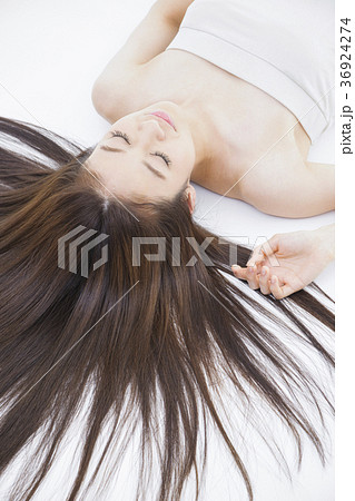 女性 寝る 眠る 仰向け 笑顔 かわいい 屋内 代 長髪の写真素材