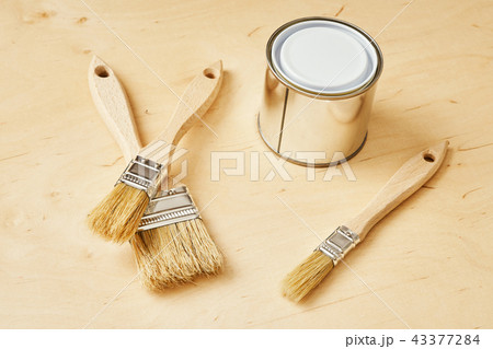 A metal can with a set of brushes for painting in an art workshop