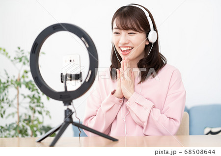 女性 スマートフォン 自撮り ポーズの写真素材