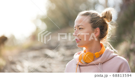 女性 女の子 ヘッドフォン パーカー 音楽の写真素材