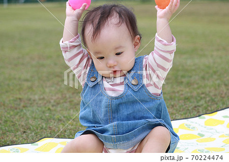 女の子 子供 ジャンパースカート 芝生の写真素材