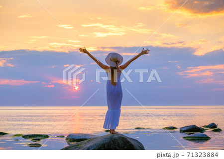 後ろ姿 女性 夕日 海の写真素材