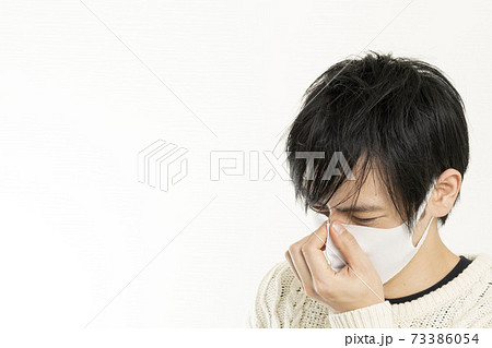 マスク姿の男性/頭痛で頭を抱える/具合が悪い独身男性/	