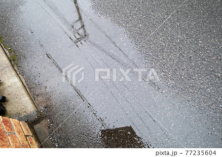 水たまり 雨 アスファルト 道路の写真素材