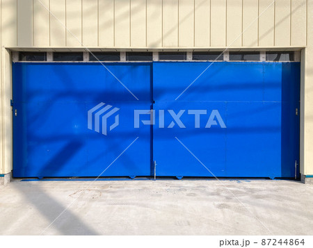 青いペンキが塗られた引き戸のある倉庫