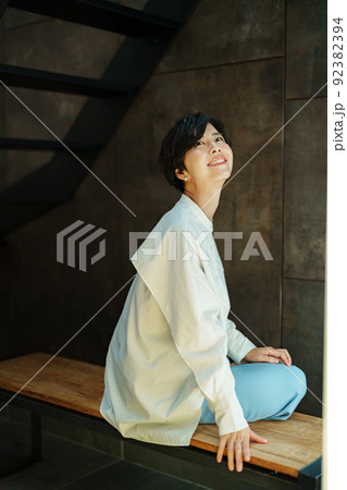 女性 座る 後姿 ベンチの写真素材