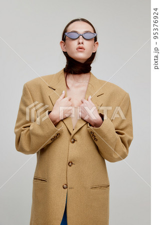 Portrait of young girl in extraordinary outfit with green coat