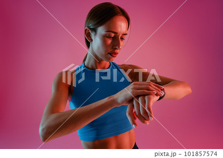 Fitness Female in White Sports Attire Adjusting Smartwatch before